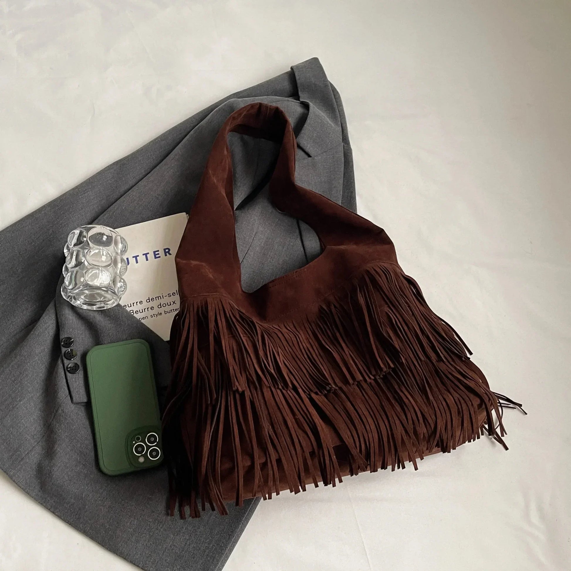 Dark brown retro leather shoulder bag with velvet tassels, large capacity, on gray blazer