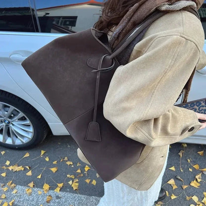 Woman carrying large brown vegan suede handbag with retro style outdoors