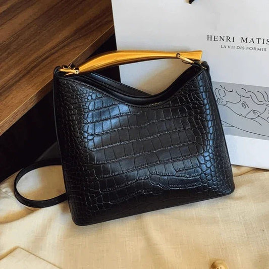 Elegant black crocodile pattern handbag for women with gold top handle and crossbody strap