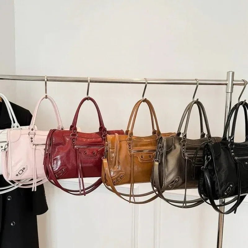 Row of stylish handbags in pink, red, brown, olive, and black with minimalist design