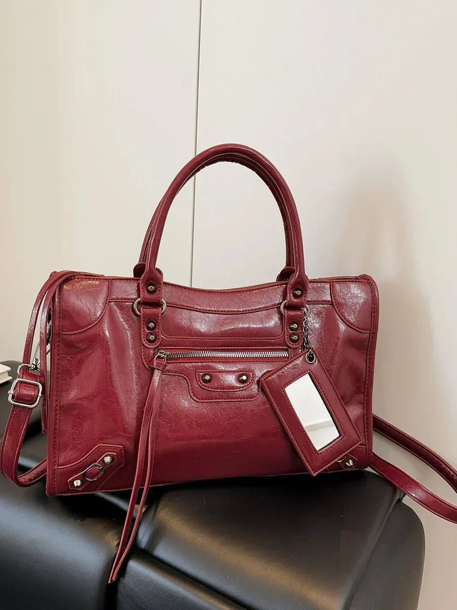 Red minimalist handbag with spacious interior, top handles, and silver hardware details