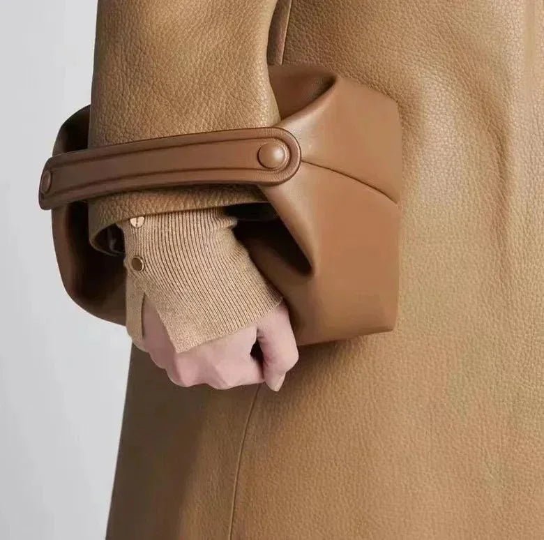 Woman holding black genuine leather handbag with unique geometric design, minimalist style